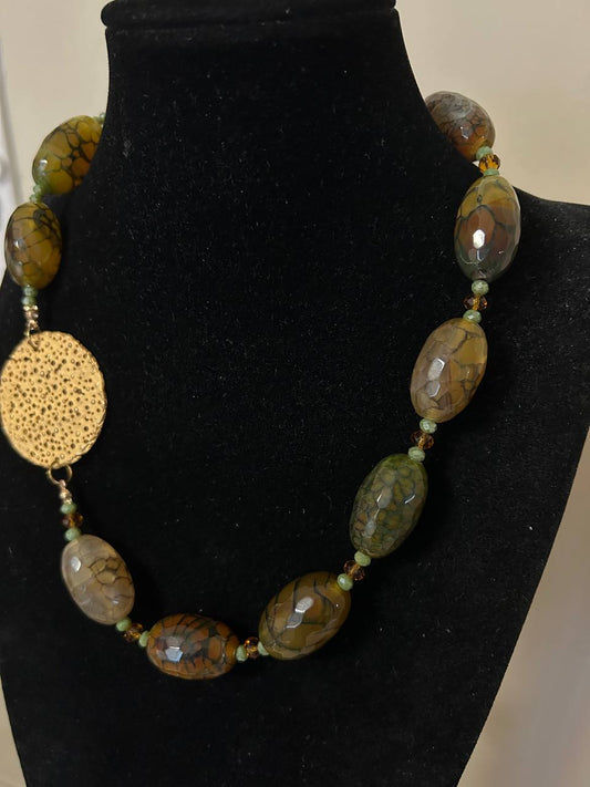Collana girocollo con pietre dure di sfumature sul marrone, verde e nero. Inserto in ottone