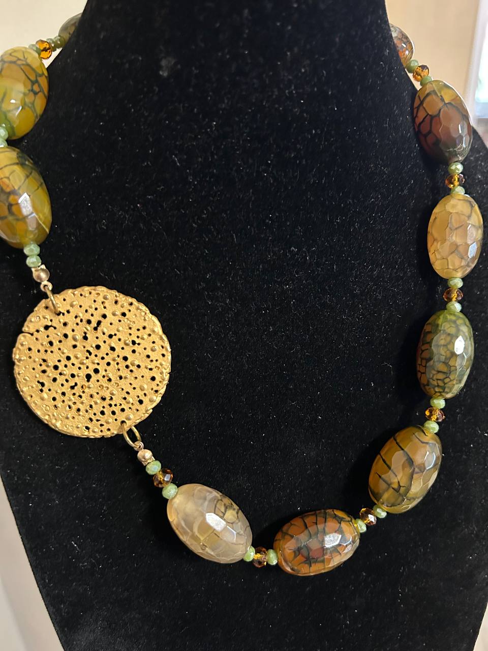 Collana girocollo con pietre dure di sfumature sul marrone, verde e nero. Inserto in ottone